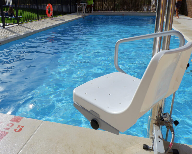 Hydraulic chair for people with disabilities at the accessible swimming pool in internal yard in Madrid, Spain