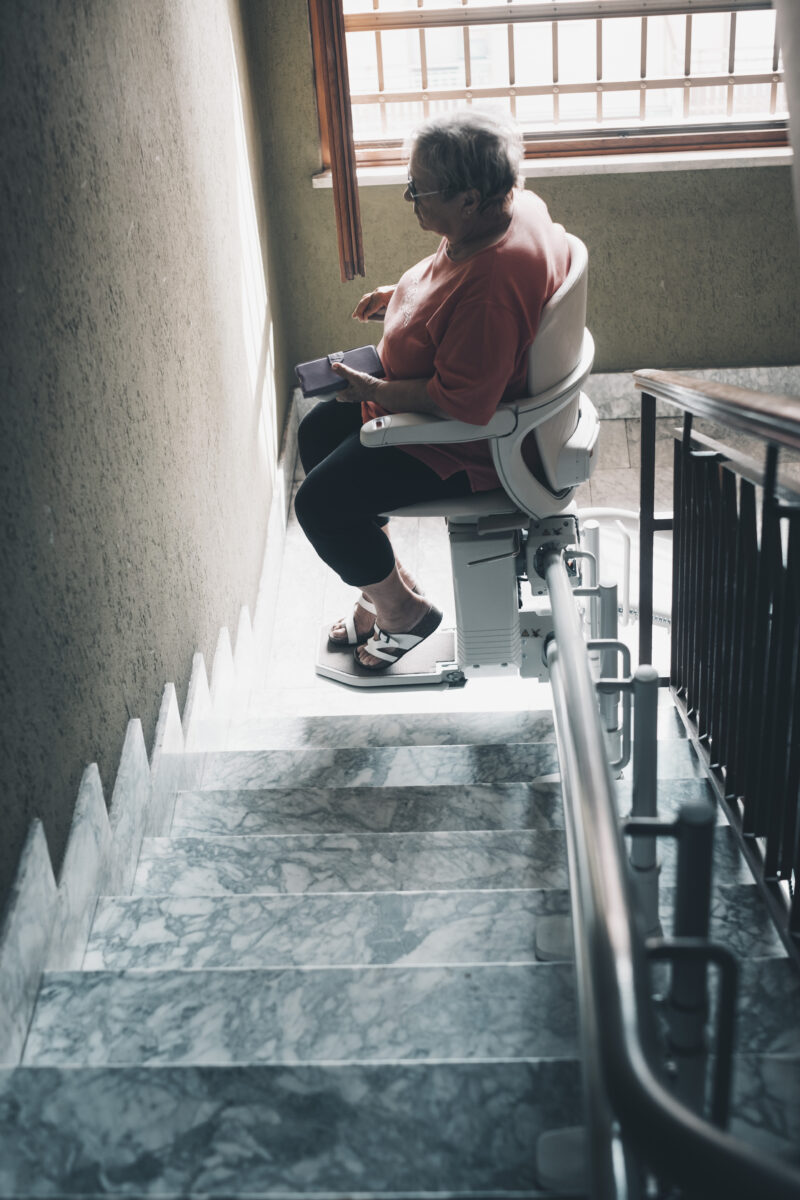 One old woman with legs problems use electric engine chair to up